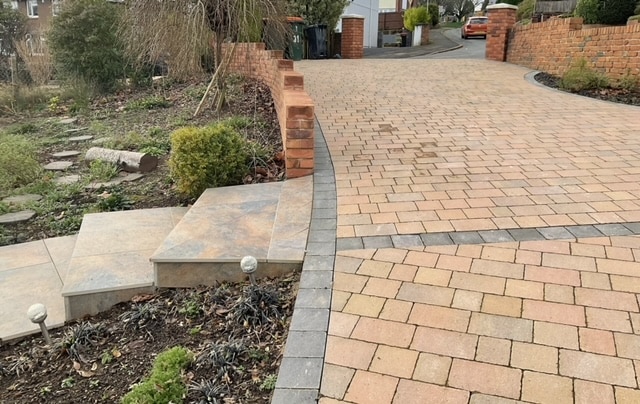 Block paved driveway with brick walling