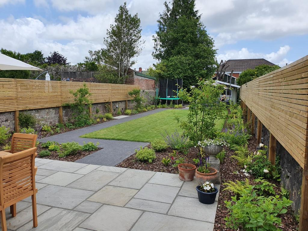 Sandstone patio and slate path in a walled garden