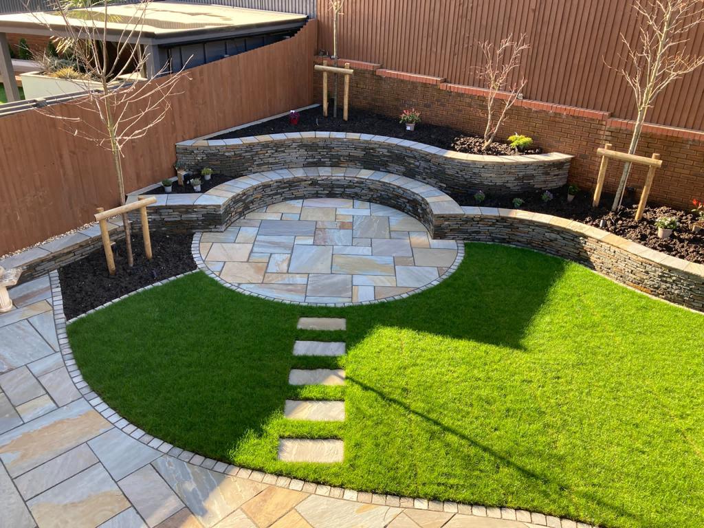 Circular sandstone feature with stone walling and new turf